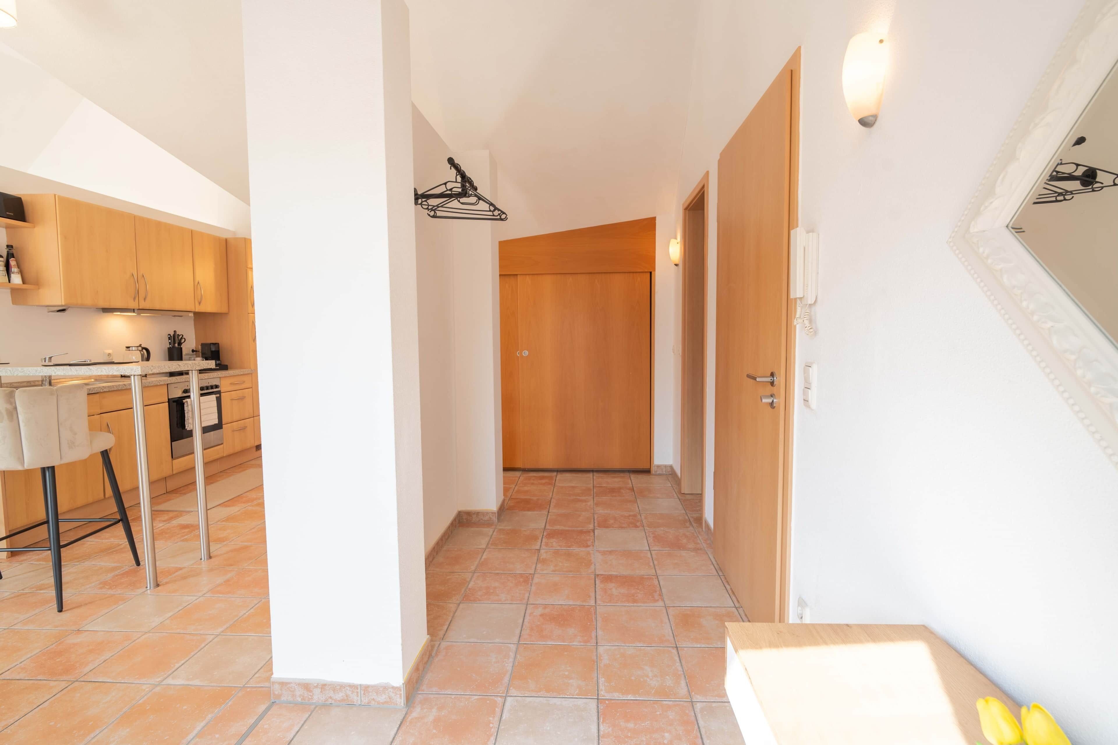 Una cocina con armarios de madera, una encimera y una silla.