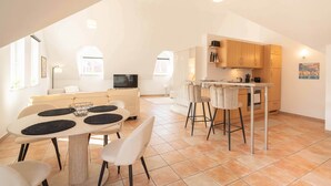 A modern kitchen with a dining area, a TV, and a bar. - Stylish Apartment | WiFi, Sky TV & Nespresso (Sobernheim)