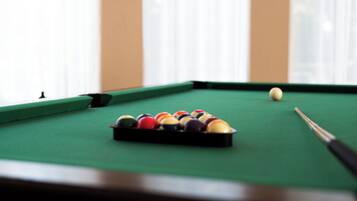 A pool table with balls and a cue stick.