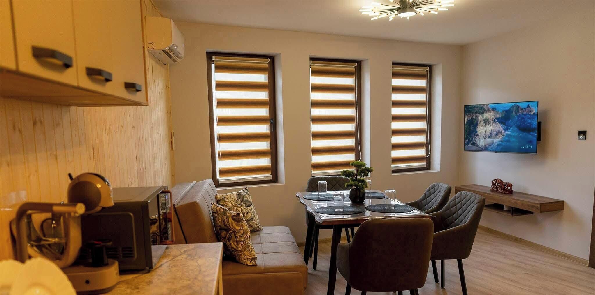 Eine moderne Küche mit Essbereich, Holzschränken, einem Fernseher und einem Bild an der Wand.