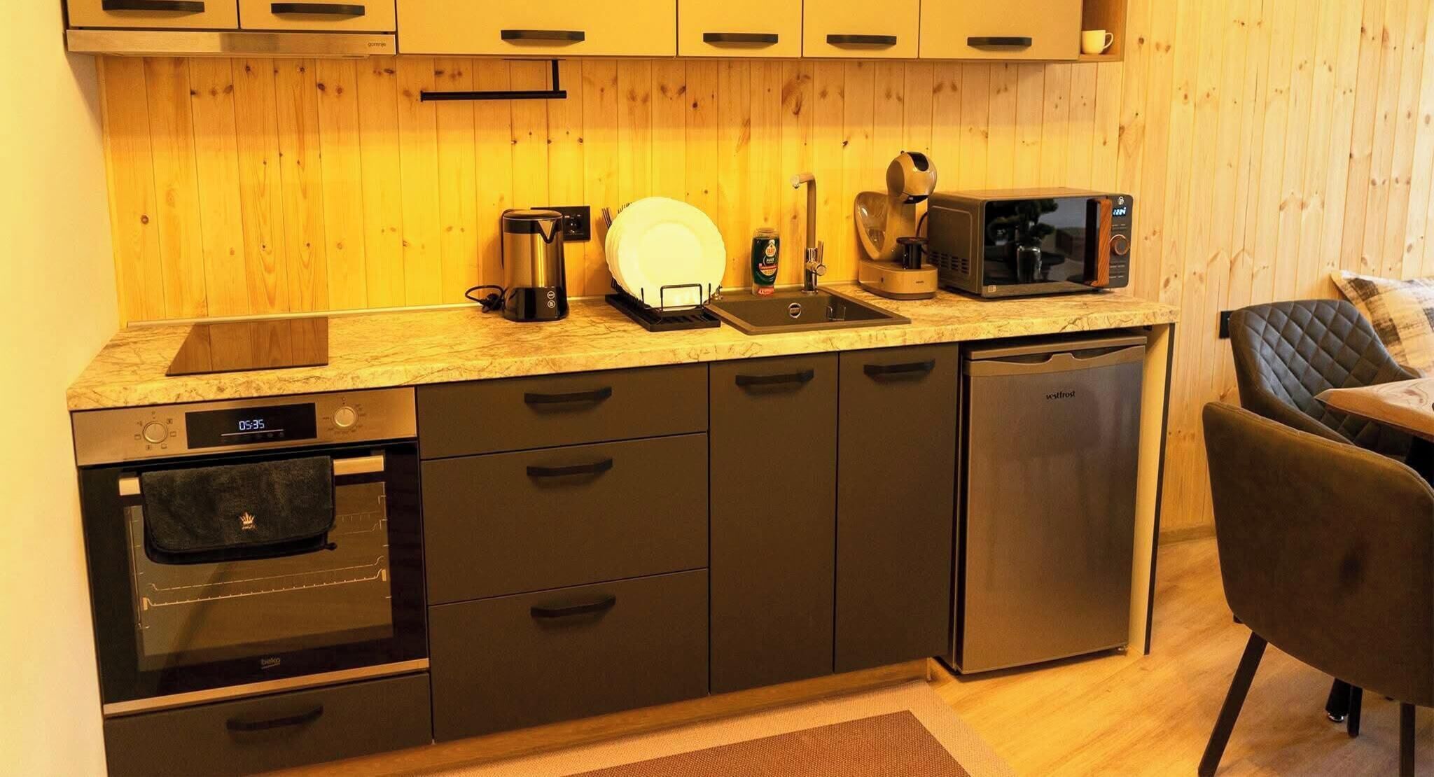 A compact kitchen with a microwave, coffee maker, and a dishwasher.