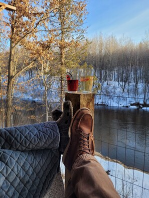 A wooden table with two glasses, a pair of brown shoes, and a quilted blanket. - Peaceful Riverfront retreat located between Rhinelander and Minocqua (Harshaw)