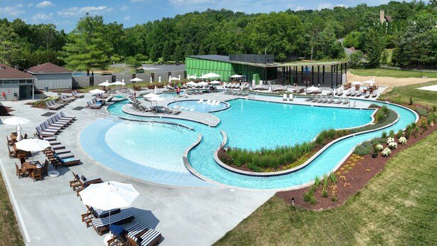 A large swimming pool with multiple lanes, sun loungers, and a covered seating area.
