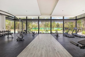 Een fitnessruimte met loopbanden, krachtapparaten en gewichten.