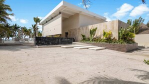 A modern building with a flat roof, large windows, and a sandy ground. - Family House w Private Pool Rooftop & BeachClub (Solidaridad)