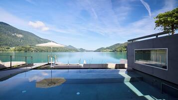 Une piscine extérieure avec vue sur un lac et des montagnes.