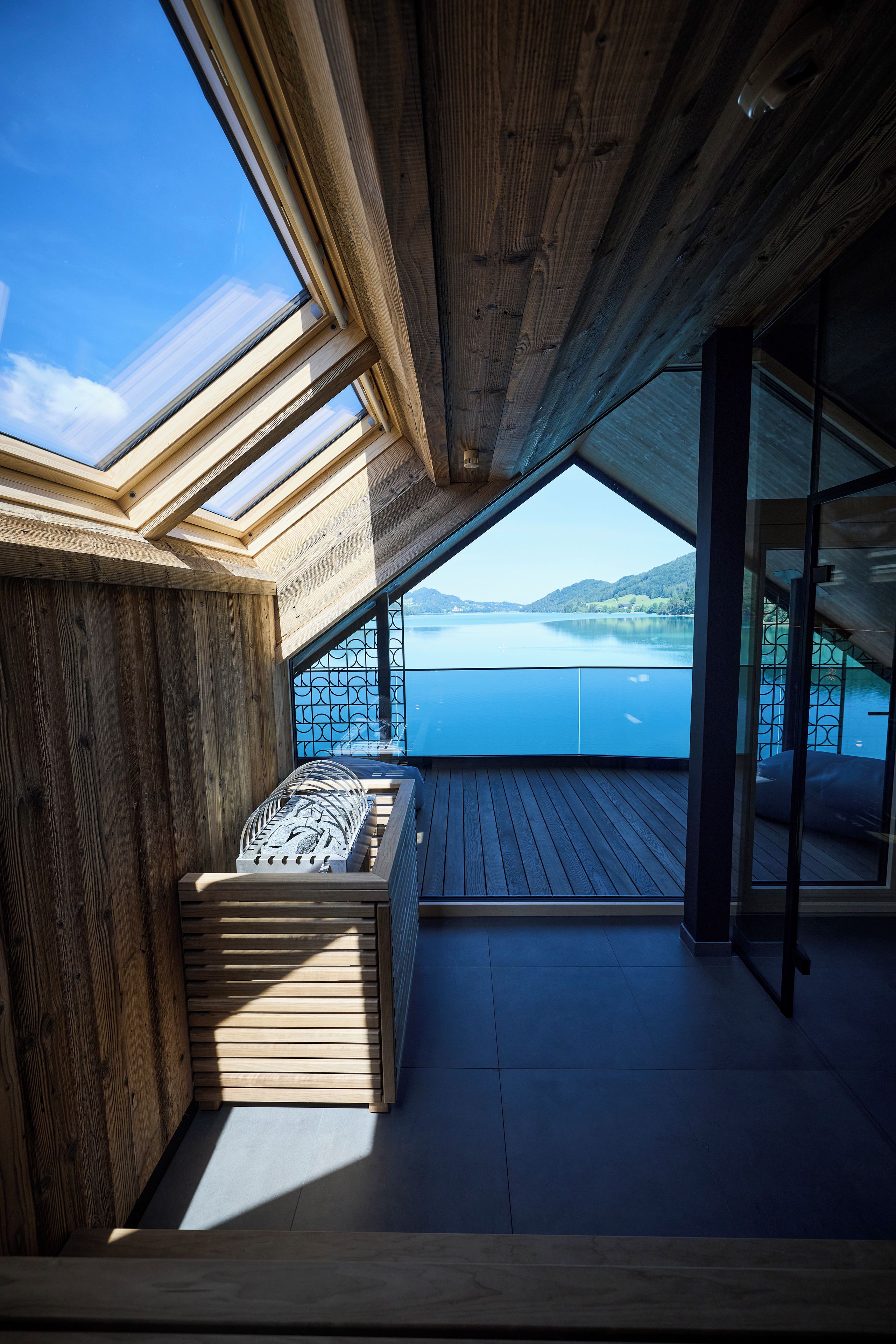 A wooden deck with a view of a lake and mountains.