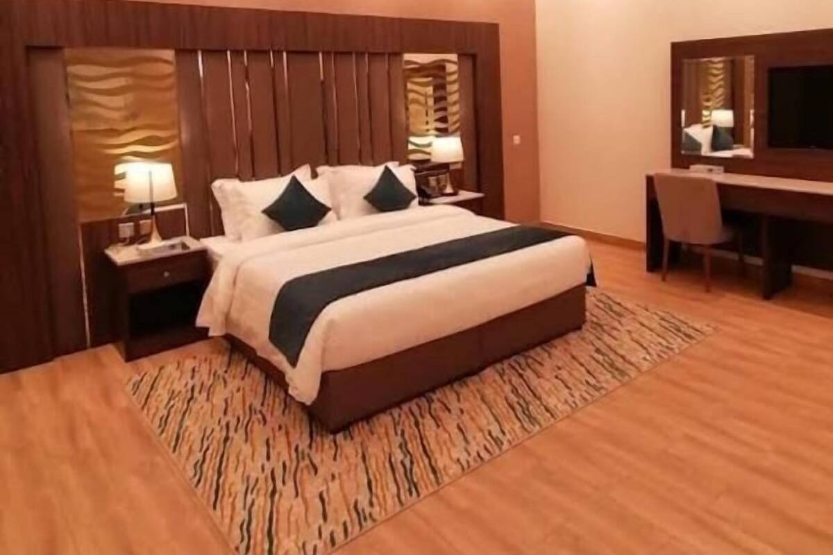 Une chambre d’hôtel moderne, dotée d’un grand lit, d’un bureau et d’une télévision.