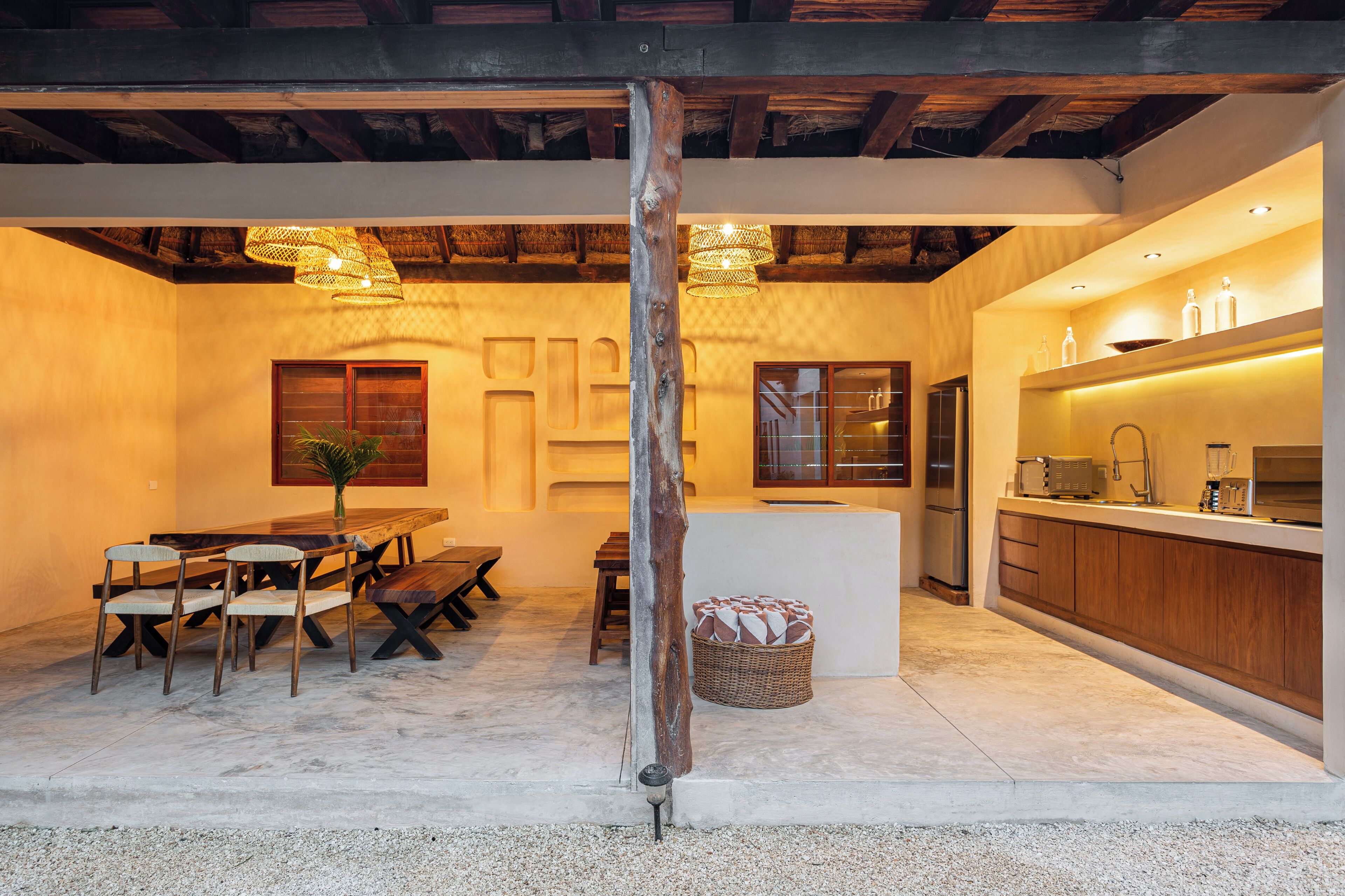An interior with a dining area, kitchen, and a central pillar.