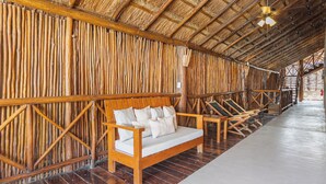 A room with a thatched roof, wooden furniture, and a wooden floor. - 9BR Villa | Sleeps 24 | Private Pool + Rooftop | Concierge & Breakfast Included (Tulum)
