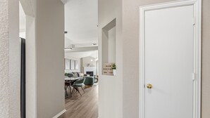 A hallway leading to a dining area with a table and chairs, a fireplace, and a door with a sign. - Lake Haven Retreat - Spacious 3BR Family Escape Near Lake Lewisville (Little Elm)
