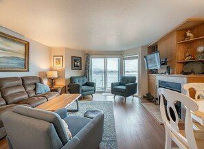 A modern living room with a sofa, armchairs, a coffee table, and a television. - Dock of the Bay Condo, Fireplace & Bay Views (Lincoln City)