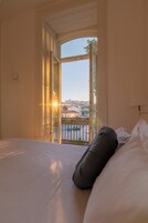 Una habitación de hotel con una cama, una ventana y vistas a la ciudad.