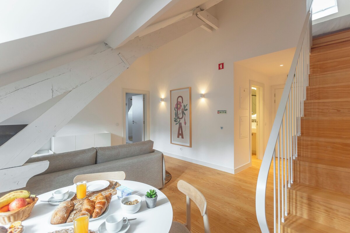 Een modern interieur met een eethoek, een trap en een gang naar een badkamer.