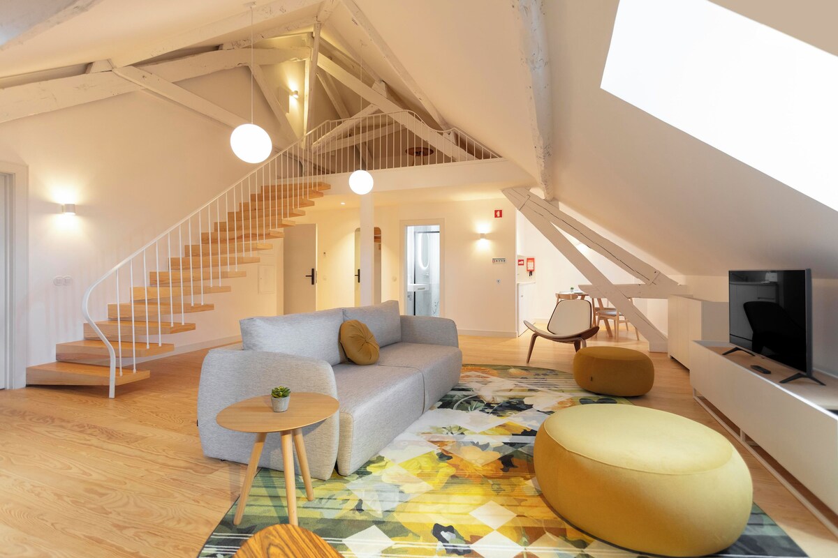 Een modern interieur met een trap, een bank, een ronde tafel en een televisie.