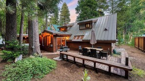 A cabin with a deck, outdoor seating, and a small porch area. - Hot Tub, Shared Pier, Forest Views in Heart of Tahoma Sugar Point by Avantstay (Tahoma)