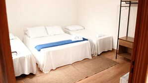 A hotel room with two beds, a wooden floor, and a wooden shelf unit. - Pousada Árvore da Vida (Bonito)