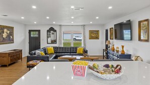 Ein geräumiges Wohnzimmer mit einer großen Couch, einem Couchtisch und einer Schüssel Popcorn.