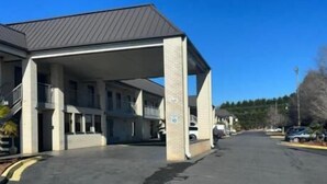 Un edificio de varios pisos con estacionamiento techado y cielo despejado.