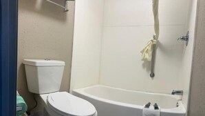 Un baño con inodoro, bañera y ducha.