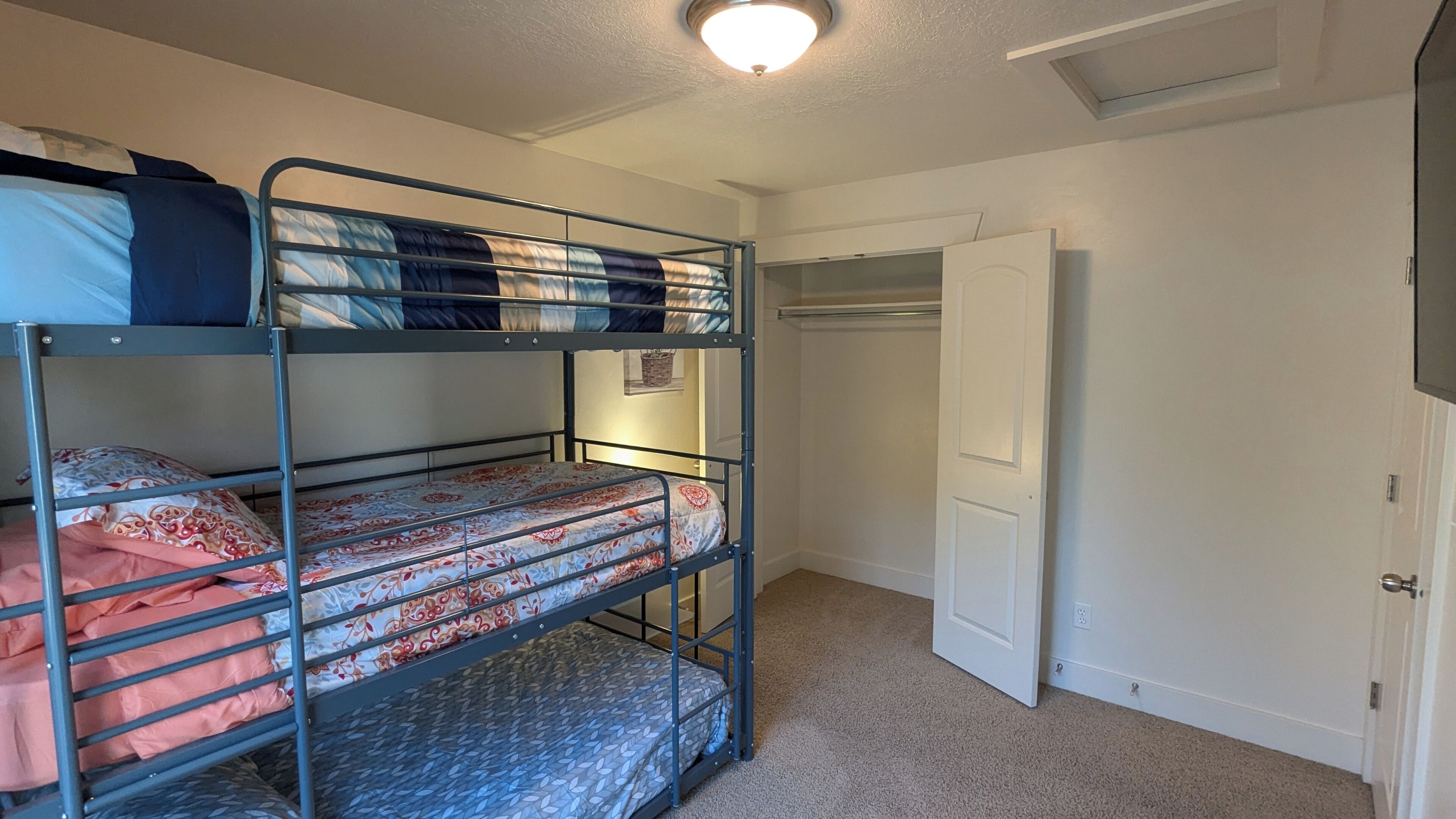 Ein Schlafzimmer mit Etagenbett, Schrank und Tür.