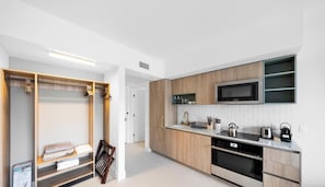 Eine moderne Küche mit Holzausstattung, einer eingebauten Mikrowelle und einer Arbeitsplatte mit verschiedenen Geräten.