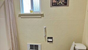 A bathroom with a toilet, bidet, bathtub, and a window. - Quaint 1-bedroom house in charming Friday Harbor perfect for getaway (Friday Harbor)