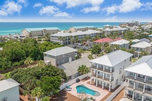 A coastal hotel with multiple-story buildings, a swimming pool, and a view of the ocean. - Destiny Awaits | 6BR | Gulf View! Private Pool & Golf Cart! Walk to Beach! (Destin)