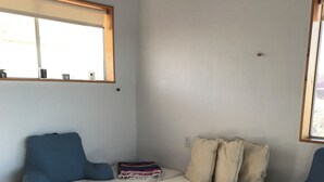 A room with a white sofa, a striped rug, and a window with a view.