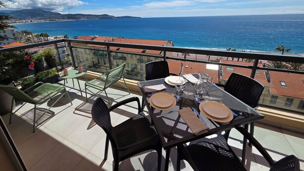 Ein Balkon mit Tisch für zwei Personen, mit Blick auf die Küste.