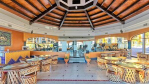 Un restaurant en plein air doté d’un haut plafond, d’un sol carrelé et de meubles en osier.