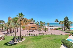 A resort with a pool, palm trees, and a beach view. - Stunning Views in 2nd Level Condo Princesa B-203 (Puerto Peñasco)