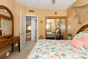 A bedroom with a bed, a dresser, a mirror, and a door leading to another room. - Stunning Views in 2nd Level Condo Princesa B-203 (Puerto Peñasco)