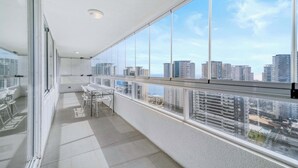 Een balkon met uitzicht over de stad, een tafel en stoelen.