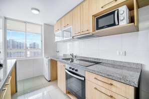 A modern kitchen with a microwave, oven, and sink.