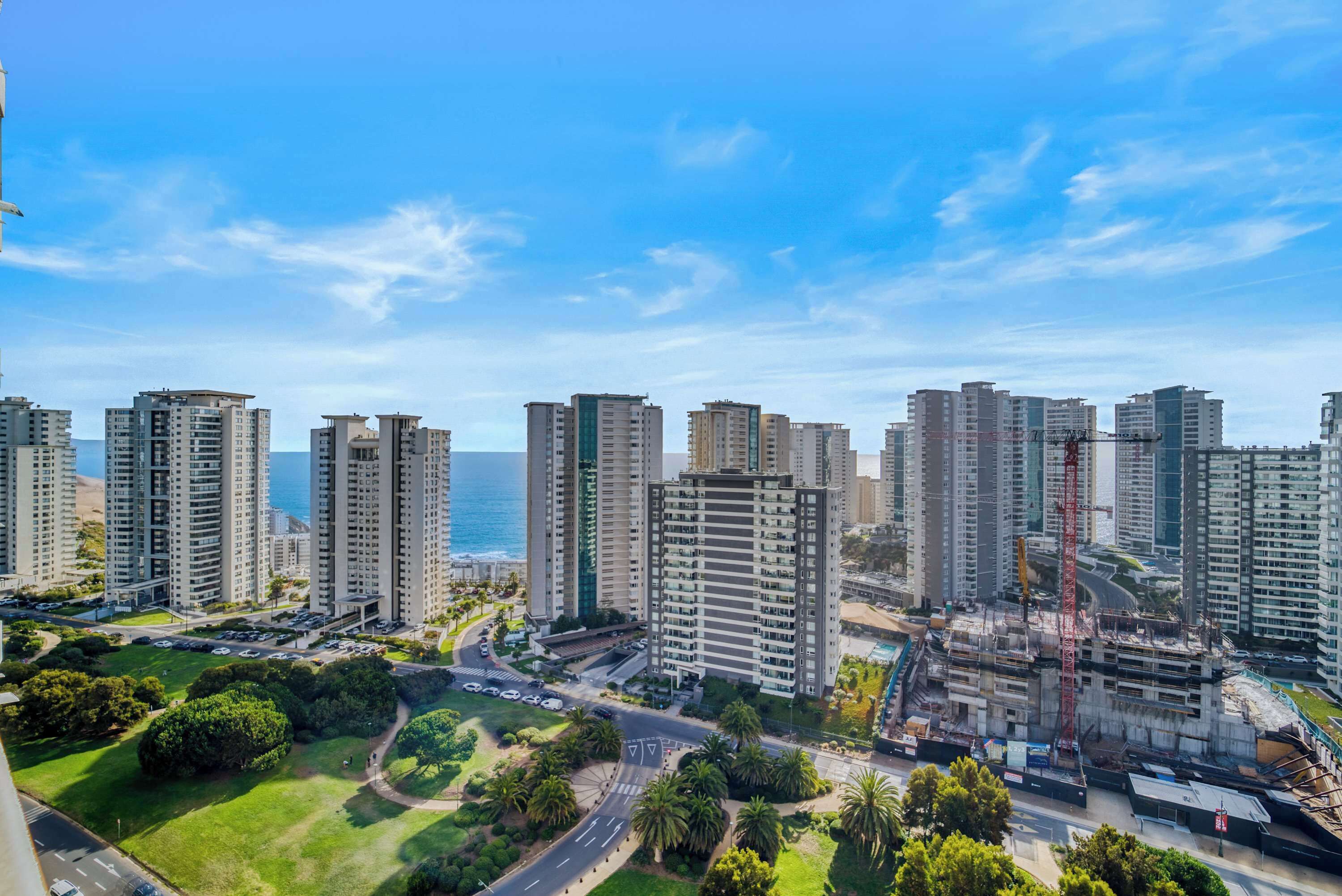 A high-rise residential area with multiple apartment buildings, a road with vehicles, and a construction site with a crane.