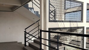 Una escalera con barandilla metálica y diseño de ventana de malla.