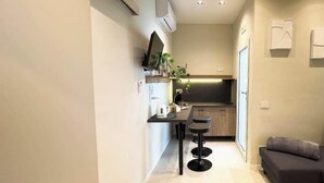 Cozinha moderna com área de jantar, sofá e pequena mesa.
