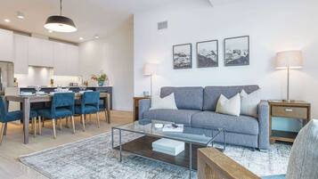 A modern living room with a sofa, coffee table, and dining area.