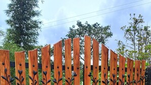 Una cerca de madera con detalles decorativos de hojas de metal.