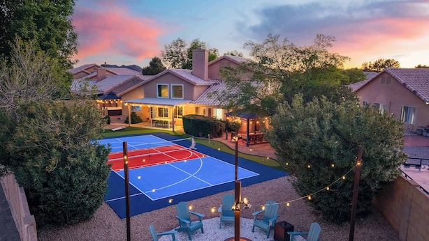 Una cancha de tenis con asientos alrededor y una chimenea.
