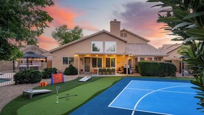 Una propiedad residencial con cancha de tenis, patio cubierto y zona de piscina.