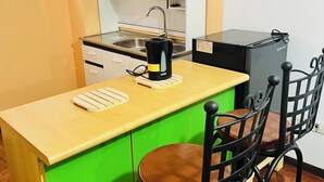 A small kitchenette with a sink, a black coffee maker, a refrigerator, and a green countertop. - Cozy studio apartment in the center, steps away from the cable car 🚡 (La Paz)