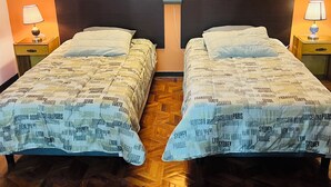 A hotel room with two beds, wooden parquet flooring, and orange walls. - Cozy studio apartment in the center, steps away from the cable car 🚡 (La Paz)