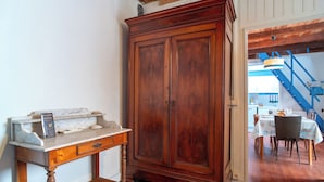 Ein Holzschrank, eine Marmorarbeitsplatte und ein Essbereich mit Tischen und Stühlen.