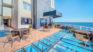 A rooftop pool area with glass flooring, outdoor seating, and a view of the ocean. - Vista Pacífico- 2D , Sea View and Wifi (Viña del Mar)