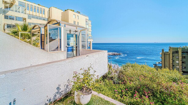 A coastal building with a glass conservatory, a balcony, and a view of the sea. - Vista Pacífico- 2D , Sea View and Wifi (Viña del Mar)