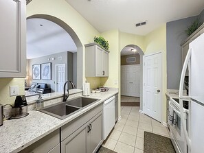 A modern kitchen with a double sink, white cabinets, and a large mirror. - **Create Magic Moments steps away from Waterpark & Pool. On Disney's Doorstep** (Kissimmee)