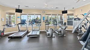 Ein Fitnessstudio mit Laufbändern, Crosstrainern und Gewichten.