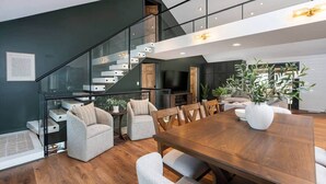 Un intérieur moderne comprenant un coin repas, un escalier et un espace de vie.